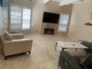 a living room with a couch and a fireplace at Pacific Breeze Right Next to Huntington Beach Pier! Steps from Beach!! in Huntington Beach