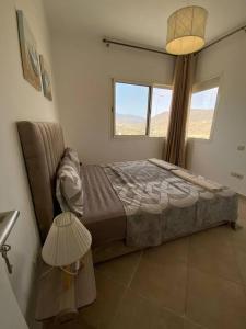 une chambre avec un lit, une lampe et une fenêtre dans l'établissement Appartement avec piscine Imi ouaddar - Family only, à Agadir