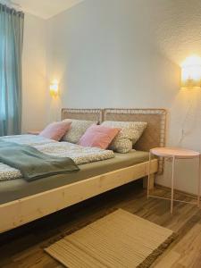 Una cama con almohadas rosas y una mesa en una habitación en Apartment Boho Living, en Bautzen 19 fotos más