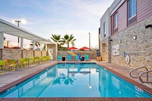 a swimming pool with tables and chairs next to a building at Home2 Suites By Hilton Livermore in Livermore