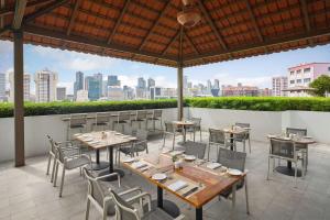 a patio with tables and chairs and a view of the city at Hilton Garden Inn Singapore Serangoon in Singapore
