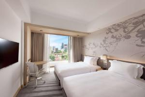 una camera d'albergo con due letti e una finestra di Hilton Garden Inn Singapore Serangoon a Singapore
