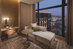 a hotel room with a bed and a large window at DoubleTree By Hilton Xiamen-Haicang in Xiamen