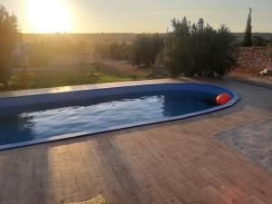 a swimming pool with a sunset in the background at Villa Caroubier in Essaouira