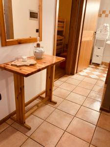 a wooden table in a kitchen with a mirror at Appartamento El Feudo in Tesero