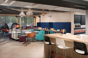 a restaurant with tables and chairs in a room at Tru By Hilton McDonough in McDonough