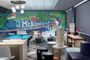um restaurante com mesa de bilhar e um mural na parede em Tru By Hilton McDonough em McDonough