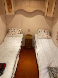 a small room with two beds and a table at ALBA Pelnik domki holenderskie in Pelnik