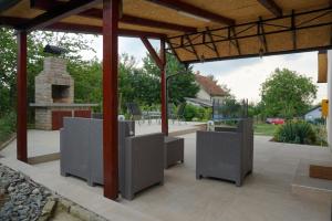 a patio with chairs and a stone fireplace at Vikendica Mali Raj in Čortanovci