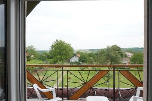 a balcony with chairs and a view of a field at Vikendica Mali Raj in Čortanovci