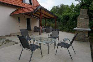 a patio with a glass table and chairs and a pavilion at Vikendica Mali Raj in Čortanovci