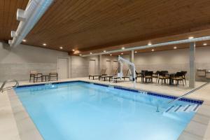 a large swimming pool with tables and chairs at Hampton Inn & Suites Seattle/Renton, Wa in Renton