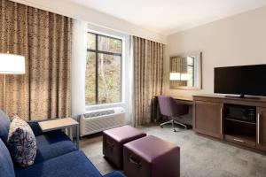 a living room with a blue couch and a tv at Hampton Inn & Suites Seattle/Renton, Wa in Renton