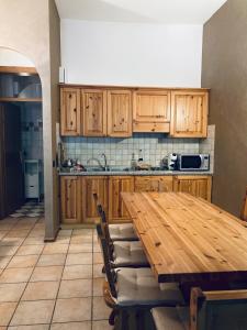 kuchnia z drewnianymi szafkami i drewnianym stołem w obiekcie Appartamento El Feudo w mieście Tesero