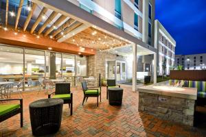 un patio con mesas y sillas en un edificio en Home2 Suites By Hilton Charles Town en Charles Town