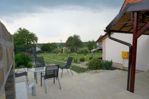 a patio with chairs and a table and a yard at Vikendica Mali Raj in Čortanovci
