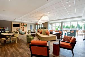 een lobby met een bank en tafels en stoelen bij Home2 Suites By Hilton Charles Town in Charles Town