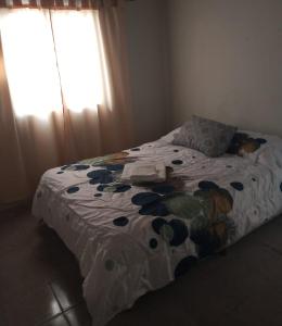 um quarto com uma cama com um edredão florido em IAUE EL HOGAR, una habitacion cocina,baño, estacionamiento compartido y patio em Luján de Cuyo