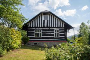 a house with a black and white striped facade at Horská Roubenka Emma in Čierne