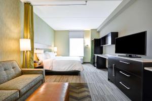 a hotel room with a bed and a flat screen tv at Home2 Suites By Hilton Charles Town in Charles Town