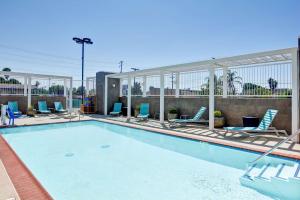 a large swimming pool with chairs at Home2 Suites Azusa in Azusa