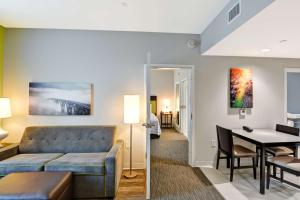 a living room with a couch and a table at Home2 Suites Azusa in Azusa