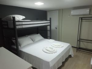Aiezza Hotel في باركارينا: غرفة نوم مع سرير بطابقين وعليها صحنين