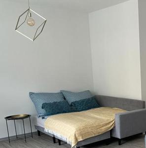 Cama en habitación con sofá y lámpara en Ferienwohnung "An der Querne" Querfurt, en Querfurt