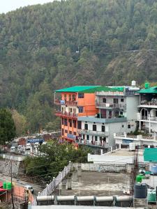 a group of buildings in front of a mountain at Hotel Maheshwari & Banquet Hall in Chamba