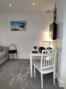 sala de estar con mesa blanca y sillas en Sea Shells, en Torquay