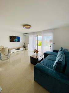 ein Wohnzimmer mit einem blauen Sofa und einem Tisch in der Unterkunft Seaview Villa Koper in Koper