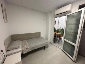 ein kleines Schlafzimmer mit einem Bett und einem Tisch in der Unterkunft Casa Sergio de Novelda in Novelda