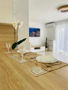 una mesa con platos y vasos y un jarrón de flores en Seaview Villa Koper, en Koper