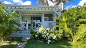 ein weißes Haus mit einer Veranda mit Hockern darauf in der Unterkunft Résidence Cocody in Sainte-Anne