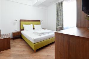 ein Schlafzimmer mit einem Bett mit einem gelben Kopfteil in der Unterkunft Helios in Sulina