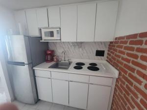 a small kitchen with a stove and a microwave at Oceana Trendy Ocean View Condo Hotel in Condado in San Juan