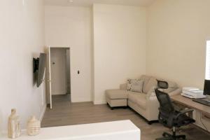 sala de estar con sofá y escritorio en Bright & Fresh Oasis Near Goodyear Ballpark, en Goodyear