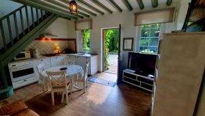 a kitchen with a table and a tv in a room at Gite Normandie in Forges-les-Eaux