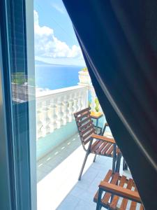 Un balcón con una silla y vistas al océano. en Hotel Abedini, en Sarandë