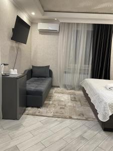1 dormitorio con cama, sofá y TV en SM Apartment, en Ereván