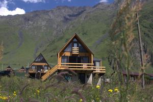 a group of cottages in front of a mountain at mood villa Kazbegi in Kazbegi