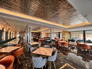 un ristorante con tavoli e sedie in una stanza di Hotel LEON - Beach Front a Shëngjin