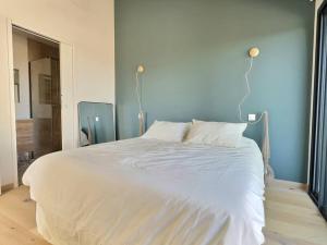 un grande letto bianco in una camera da letto con due lampade di Sous le « Figuier » a Cornillon-Confoux Altre 38 foto