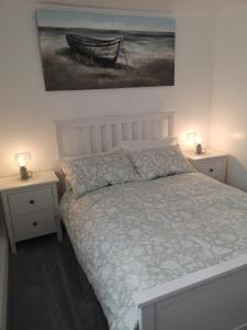 a bedroom with a bed with a painting on the wall at Sea Shells in Torquay