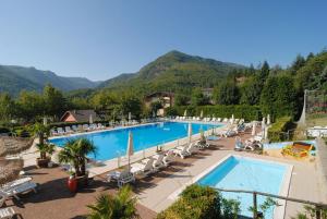 a resort with a pool and mountains in the background at Casa Blanche in Fanano