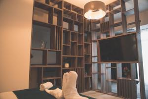 a person laying on a bed in front of a book shelf at Unique Garden Hotel in Brăila