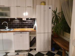 a white refrigerator in a kitchen next to a table at Tina's Apartment in Pori