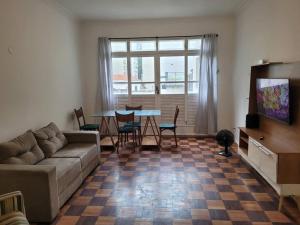 ein Wohnzimmer mit einem Sofa und einem Tisch mit Stühlen in der Unterkunft Suhcasa Leme Beach 3 quartos in Rio de Janeiro