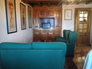 a living room with a blue couch and a tv at Casa barrio el Reloj - Lastres in Lastres