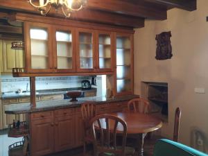 a kitchen with a wooden table and a dining room at Casa barrio el Reloj - Lastres in Lastres